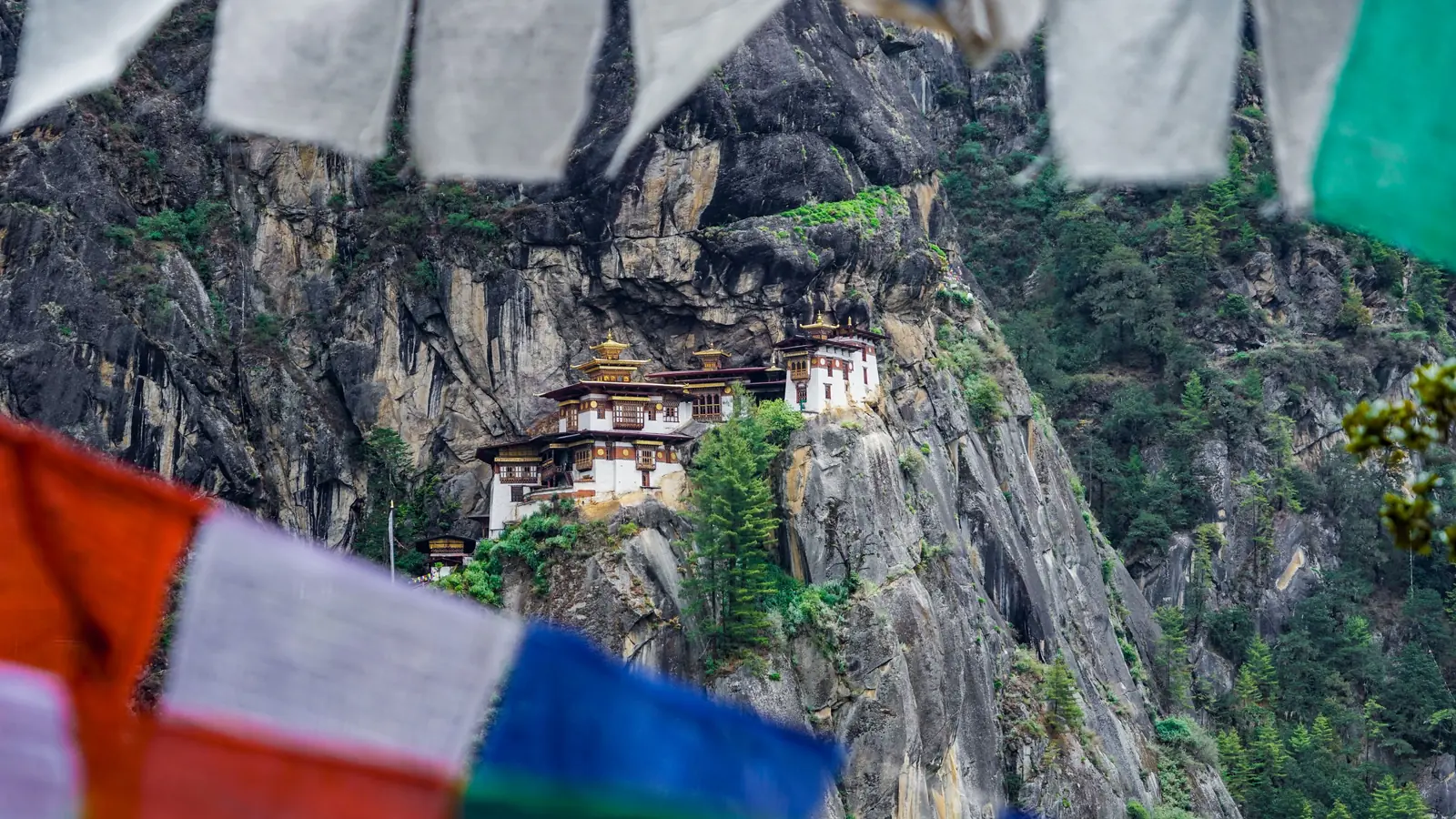 Tiger’s Nest monastery on its cliff in Bhutan, seen past prayer flags in the foreground