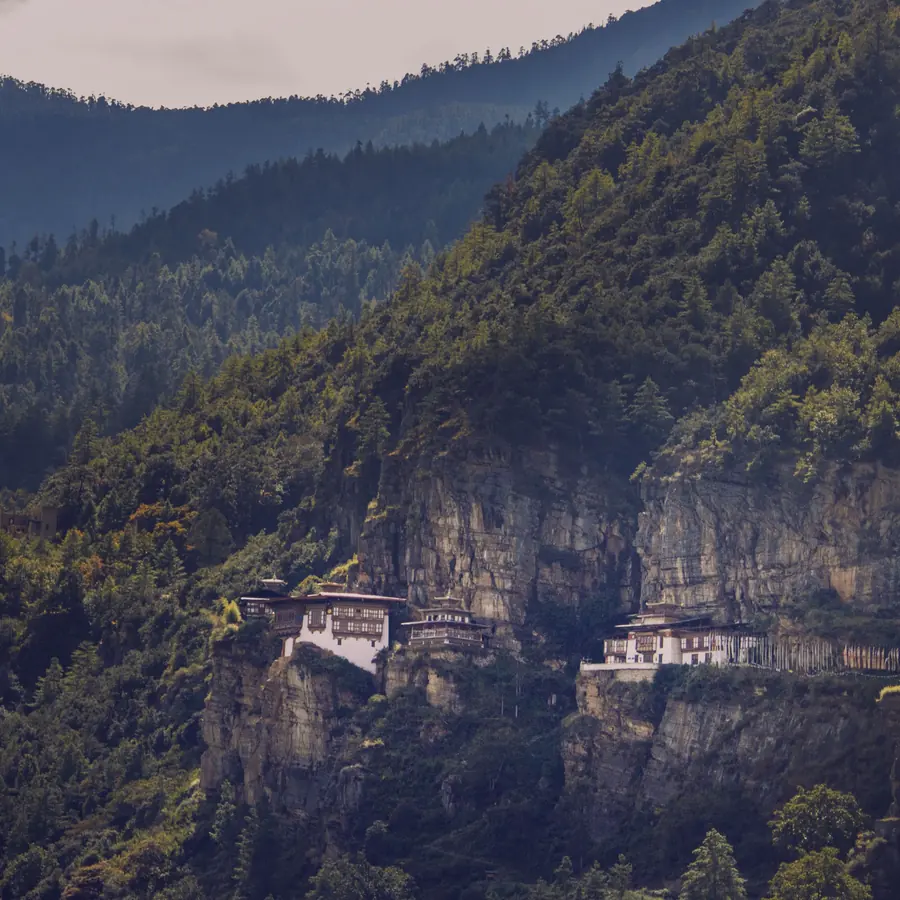 The famous Tiger's Nest Monastery perched on a cliffside in Bhutan's lush mountains