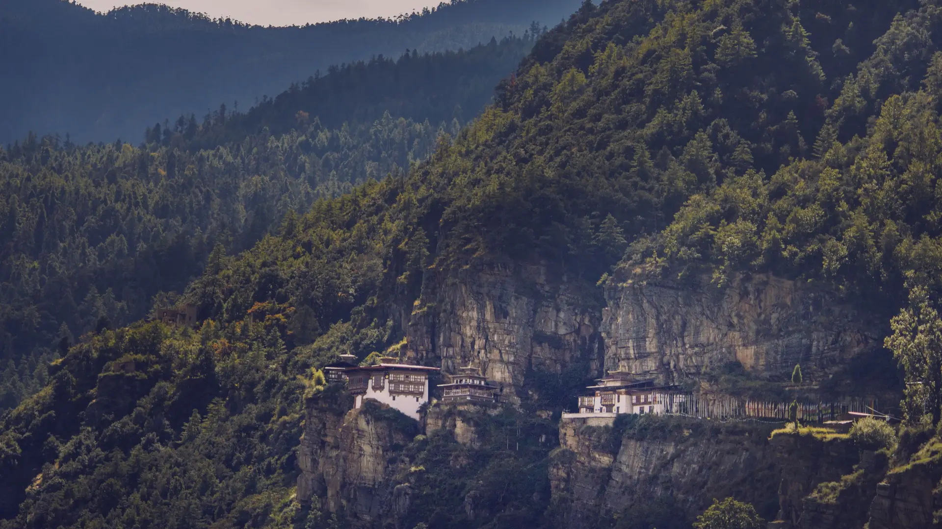 The famous Tiger's Nest Monastery perched on a cliffside in Bhutan's lush mountains