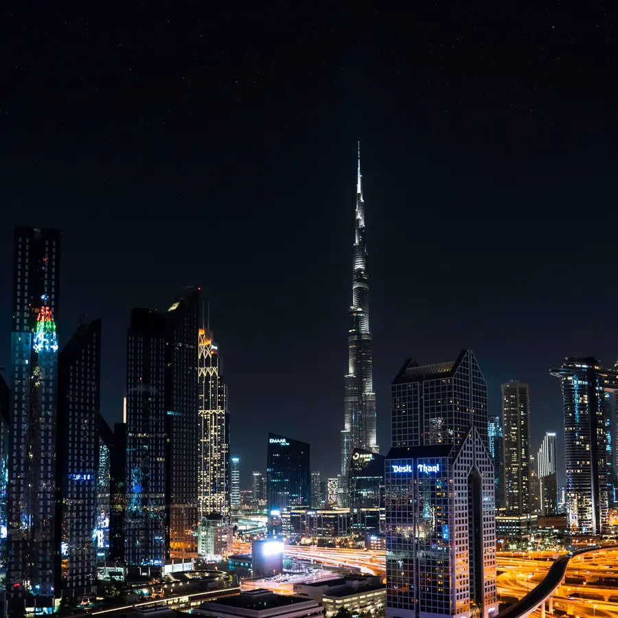Stunning nighttime view of Dubai's skyline with the iconic Burj Khalifa illuminated under a starry sky