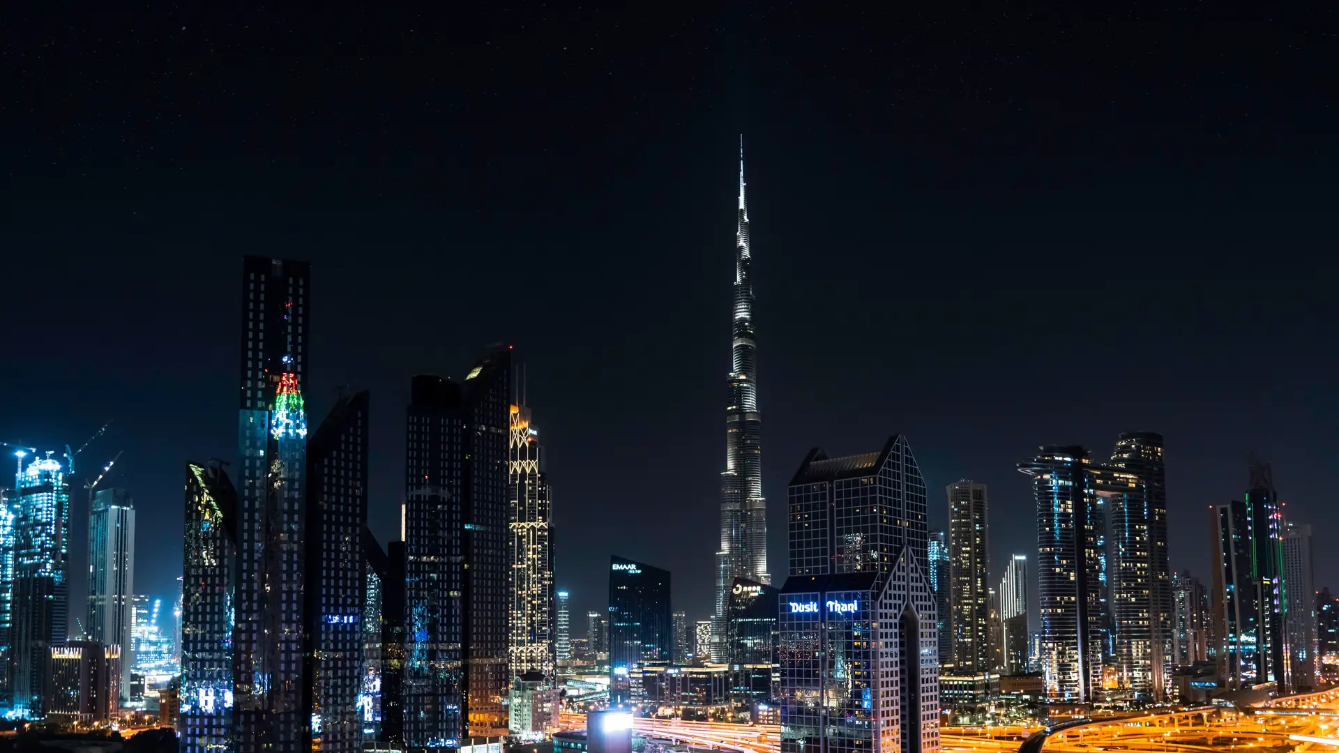 Stunning nighttime view of Dubai's skyline with the iconic Burj Khalifa illuminated under a starry sky