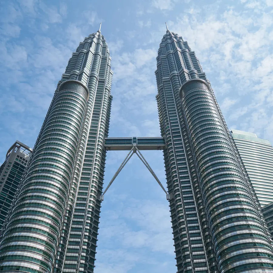 The iconic Petronas Twin Towers against a bright blue sky in Kuala Lumpur, Malaysia