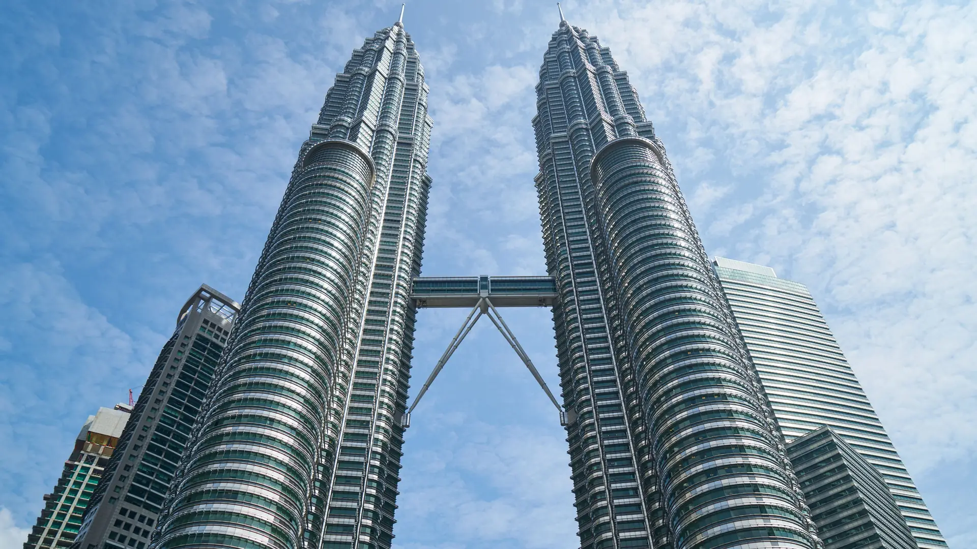 The iconic Petronas Twin Towers against a bright blue sky in Kuala Lumpur, Malaysia