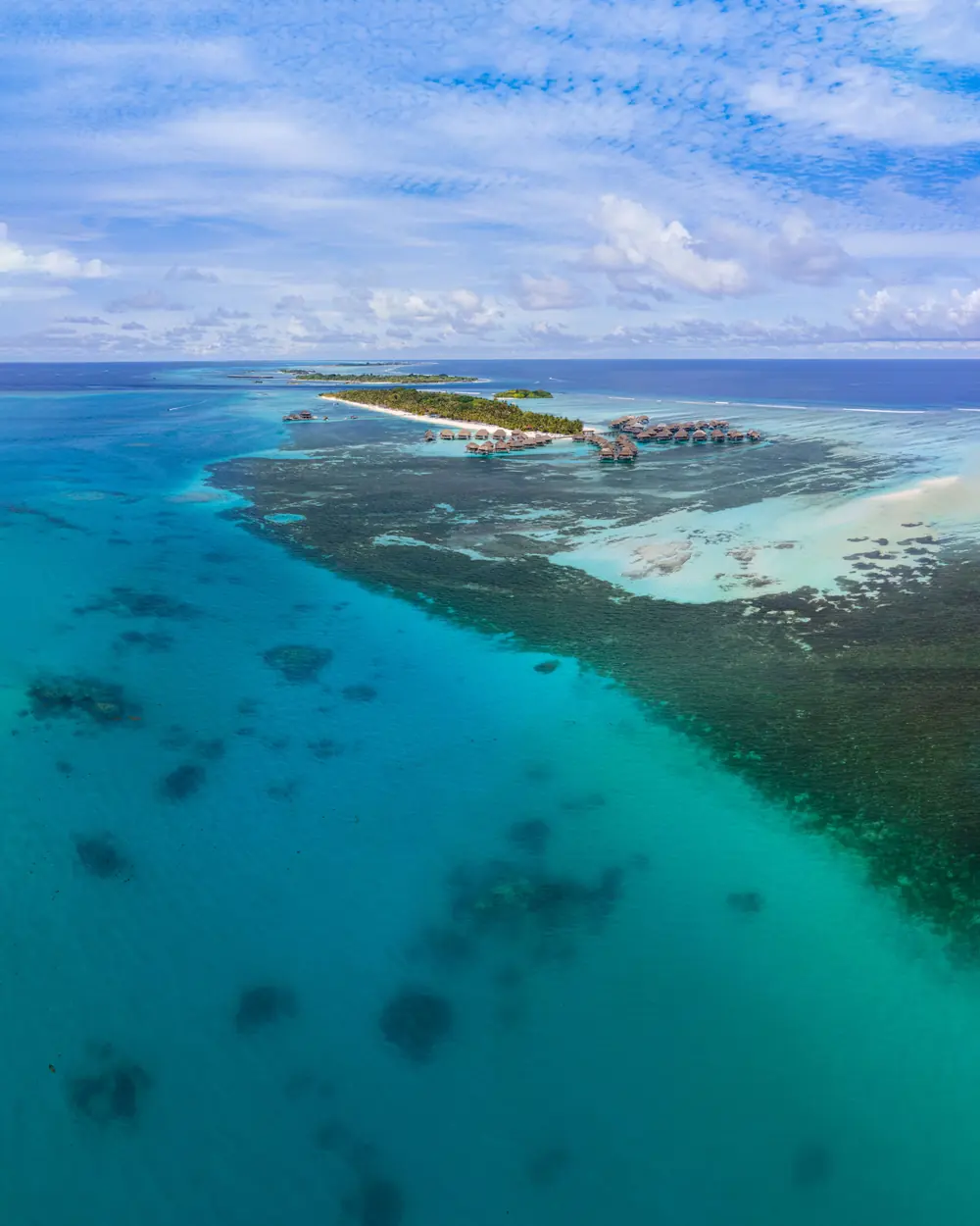 Stunning aerial view of Maldives island resort surrounded by turquoise ocean water and coral reefs
